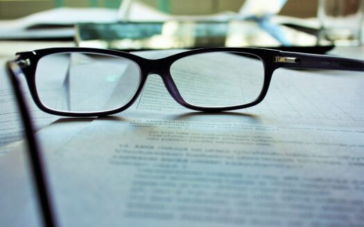 black-framed eyeglasses on white printing paper