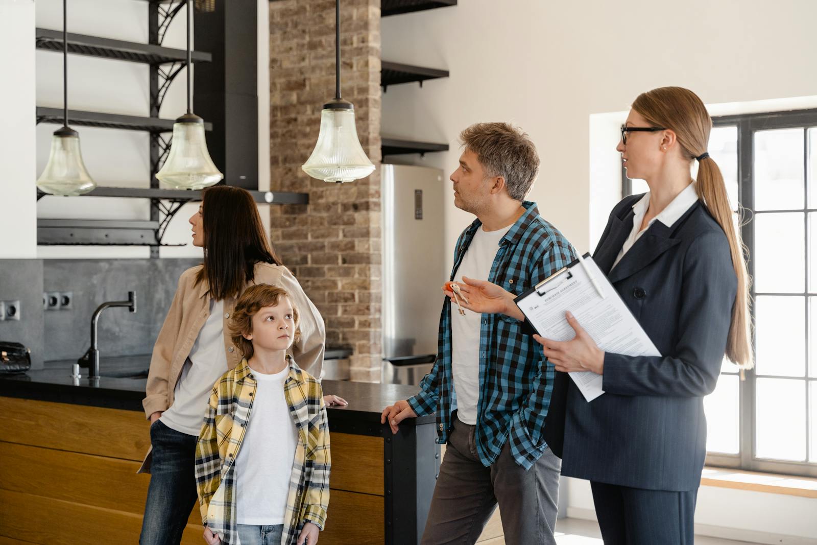 A family converses with a real estate agent about a modern home interior.